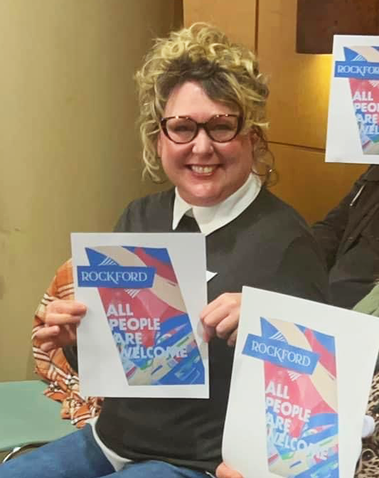 LWVGR member, Jeannie Griffith, holds up a photo of the welcome sign at the Rockford City Council meeting Feb. 24, 2025.